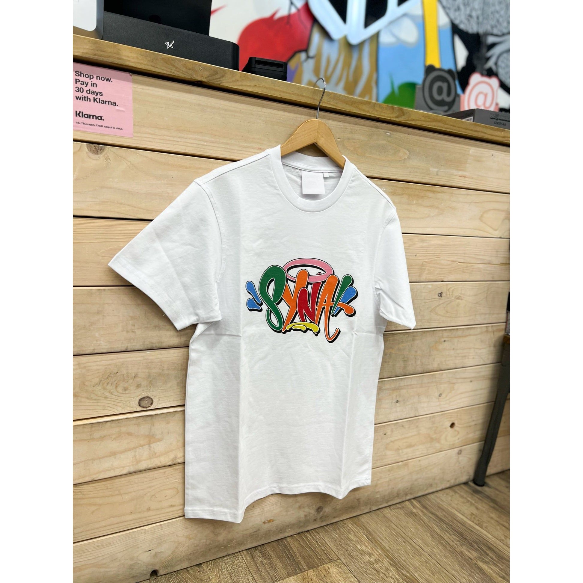 Syna World Glastonbury T-Shirt White by SYNA in Clothing. Available at KershKicks for £85.00. A must-have for fans of SYNA looking to elevate their style with this T-Shirt.