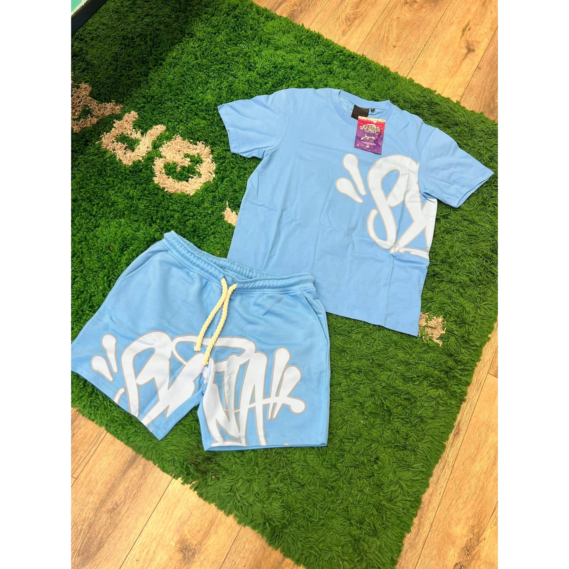 SYNA WORLD LOGO T SHIRT & SHORT SET - BLUE by SYNA in Clothing. Available at KershKicks for £225.00. A must-have for fans of SYNA looking to elevate their style with this General.